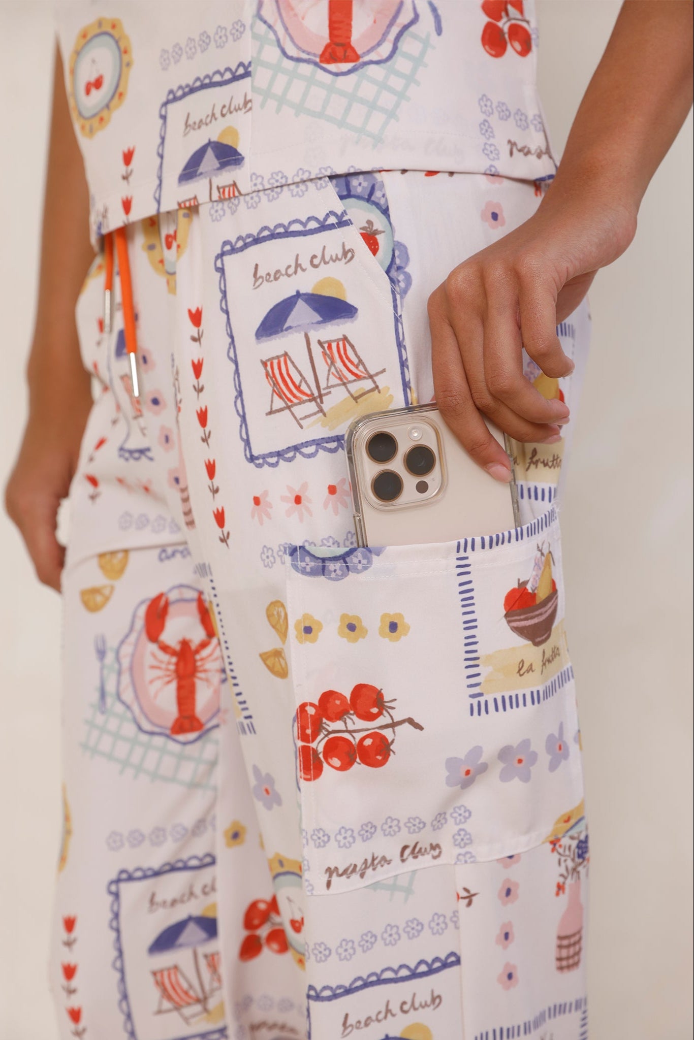 Close-up of Positano Women’s Performance Scrub Pants pocket with iPhone being placed inside, showing functional design and stretch fabric