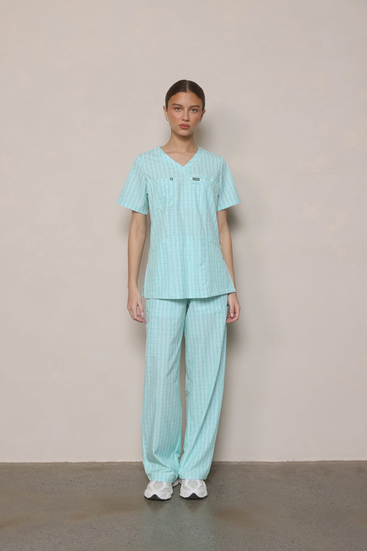 Model standing front-on wearing Hero Scrubs Mint women’s scrub top and pants