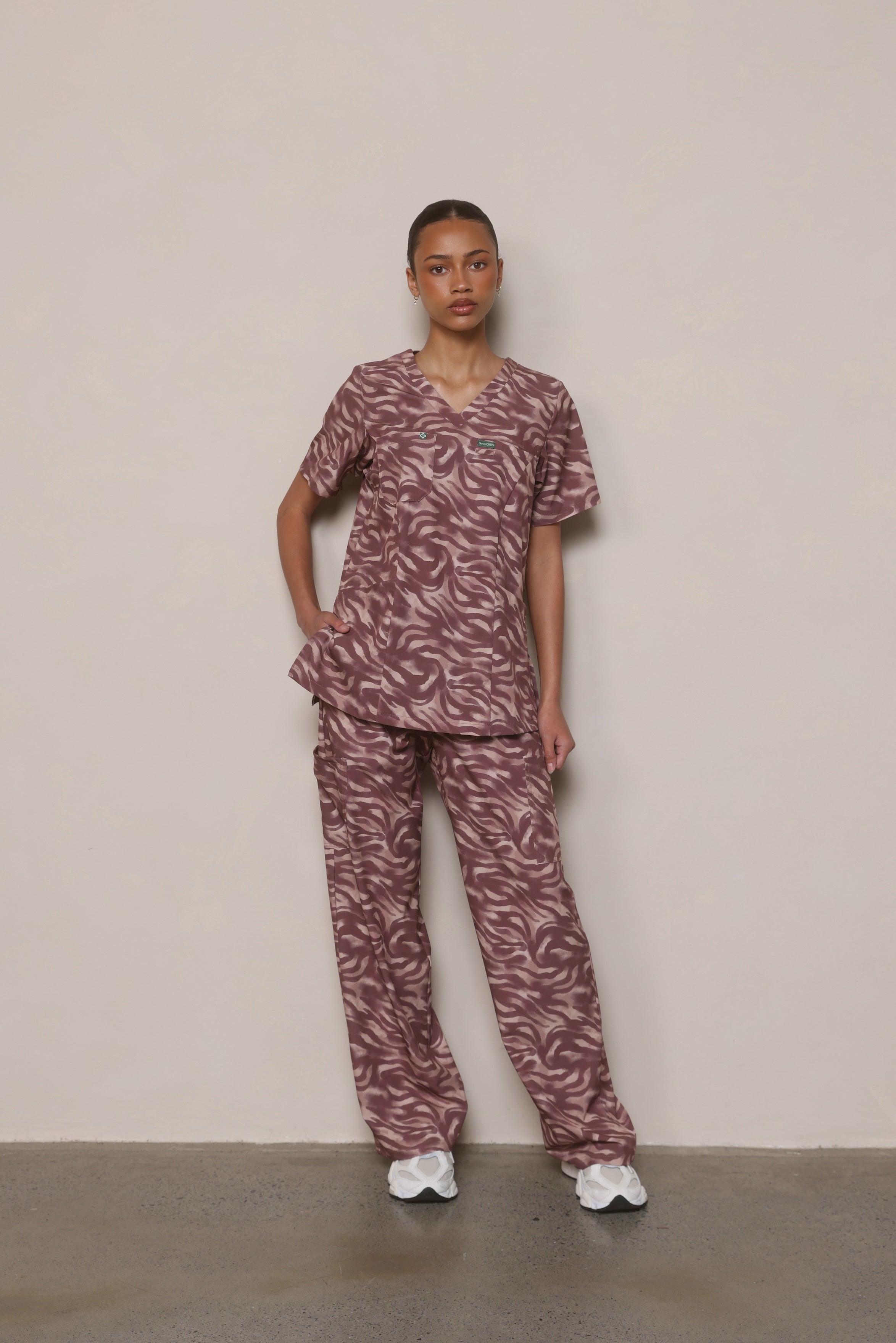 Model wearing Hero Scrubs Zebra women’s printed scrub set